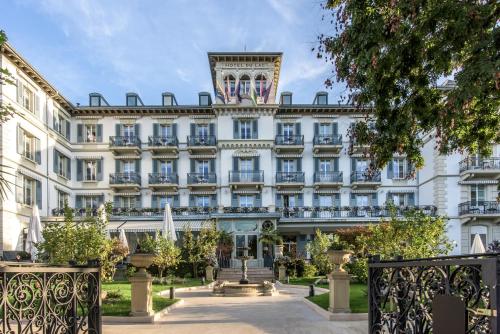 沃韦Grand Hotel du Lac - Relais & Châteaux的一座白色的大建筑,顶部设有钟楼
