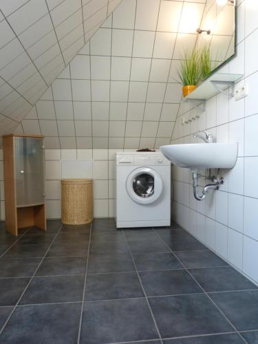克吕茨Ferienwohnung Sommerwind的一间带洗衣机和水槽的浴室