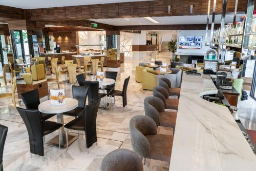 卡米尼亚波塞冬酒店的一间带桌椅的餐厅和一间酒吧