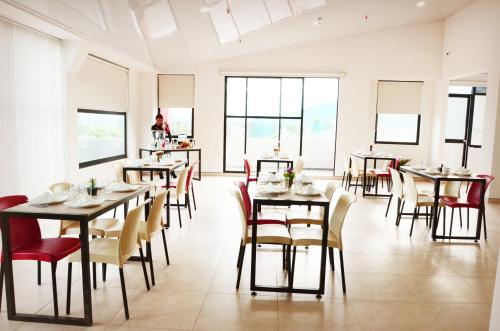 杜伊塔马HOTEL OLIMPIA的用餐室设有桌椅和窗户。