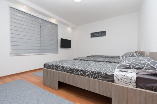 萨拉热窝Apartman Emir 1的一间卧室配有一张床和一个带百叶窗的窗户