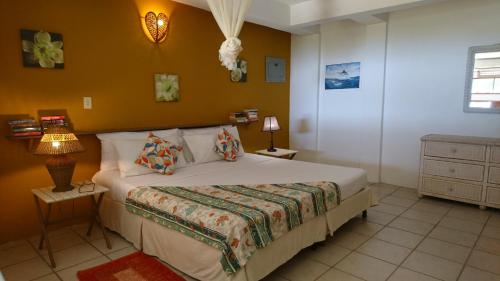 BuccooThe Nest Tobago Apartments的一间卧室设有一张床和黄色的墙壁