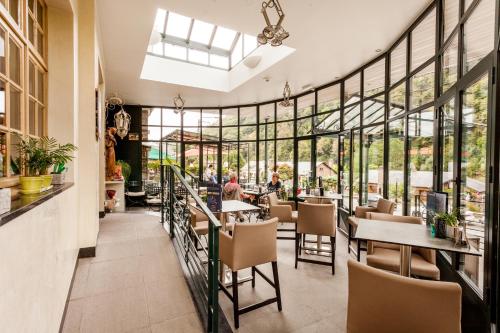 阿勒菲夫德里博香特酒店的餐厅设有桌椅和大窗户。