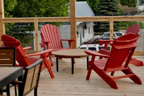 CrosbyCrosby Lofts的庭院里设有四把红色椅子和一张桌子