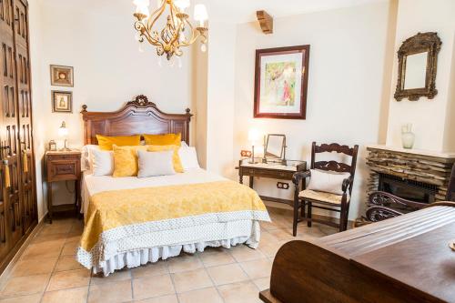 埃尔博斯克Mafloras Suites El Bosque的一间卧室配有一张床、一张桌子和一个壁炉