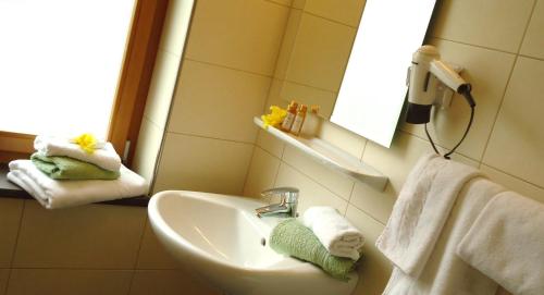 韦尔图尔诺克兰姆沃特酒店的浴室配有盥洗盆、镜子和毛巾