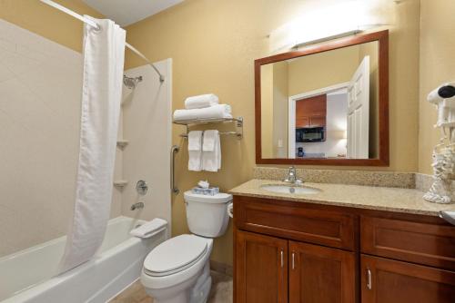休斯顿Extended Stay America Suites - Houston - IAH Airport的一间带卫生间、水槽和镜子的浴室