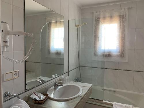 托米尼奥努埃瓦科利纳酒店的一间带水槽、淋浴和镜子的浴室
