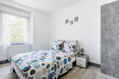 圣路易Comfort Stay Basel Airport 1B46的一间卧室配有一张带蓝色和白色棉被的床