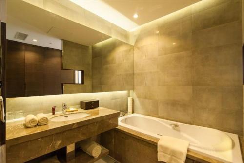 滨海新区格林良木酒店（原天津格林园酒店）的浴室配有盥洗盆和浴缸。