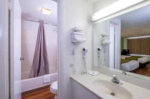 卡莱尔American Inn的白色的浴室设有水槽和镜子