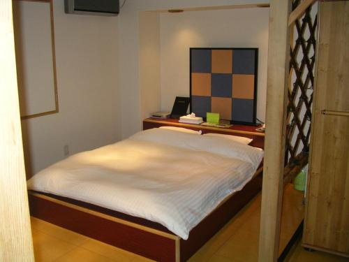 二世古新雪谷有乐酒店的一间小卧室,配有一张床和一张书桌