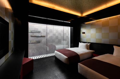 京都eph KYOTO的酒店客房设有两张床和窗户。