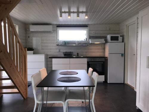 哈尔姆斯塔德Stugcentralen Stuga 24的一间小房子里的厨房,配有桌椅