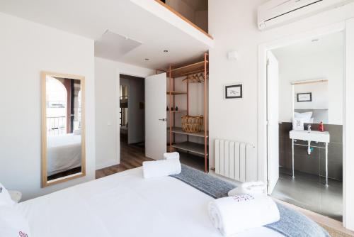 特拉萨Petit Luxe Tobella Dreta的白色卧室设有一张大床和一个水槽