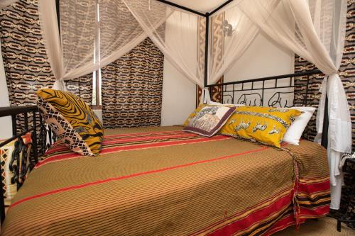 阿鲁沙Korona House Hotel的一间卧室配有一张带天蓬的床