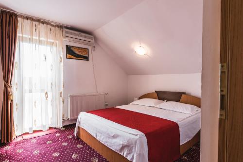 布雷亚扎Raza de Soare的一间卧室配有一张带红色毯子的大床