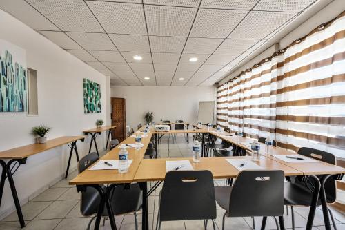 维特罗勒Appart'City Classic Marseille Aéroport - Vitrolles的大型客房配有木桌和椅子。