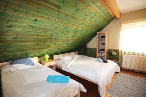 SuuresadamaPõhja Tooma Holiday Houses的一间卧室设有两张床和木墙