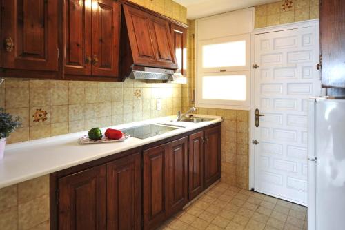 莱斯卡拉Escalabeach的厨房配有木制橱柜、水槽和冰箱。
