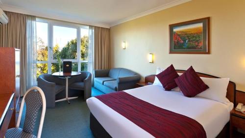 肯图巴高山汽车旅馆的酒店客房带一张大床和一把椅子