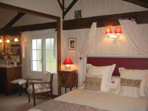 特里泽La Roseraie的一间卧室配有一张床、一张书桌和一个窗户。