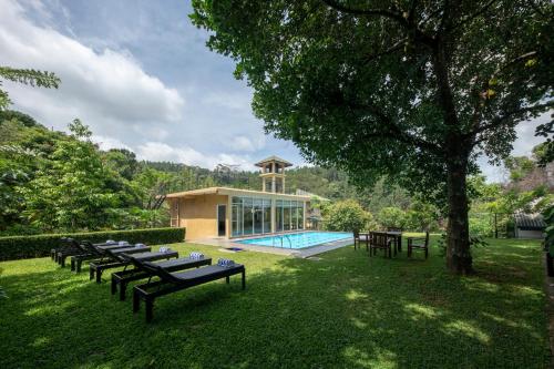 康提Melheim Kandy Villas的一组桌子和一个院子内的游泳池