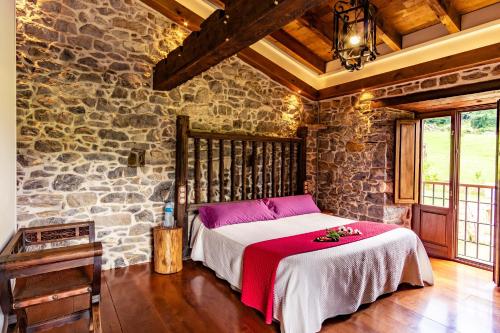 Serrapio卡斯塔努酒店的卧室配有一张石墙床