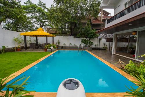 罗纳瓦拉EL Lodge by StayVista - Pool, lawn, and a charming gazebo for your perfect getaway的一座房子后院的游泳池