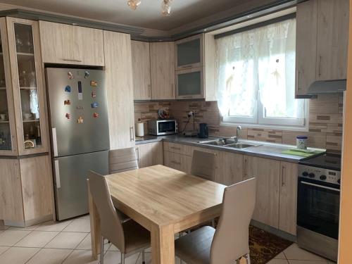 萨索斯Rania House的厨房配有木桌和冰箱。