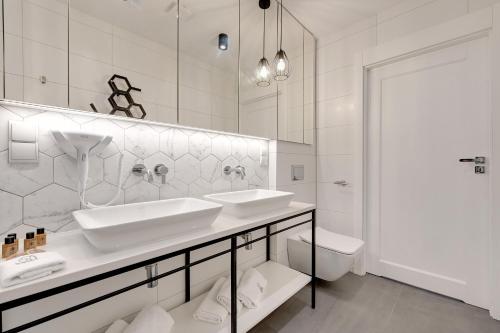 索波特Pogodna Apartments的白色的浴室设有2个盥洗盆和1个卫生间。
