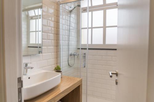 丰沙尔Funchal Village Studios的白色的浴室设有水槽和淋浴。