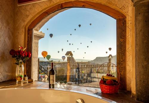 格雷梅卡帕多西亚洞穴酒店的浴缸位于带气球窗户的房间
