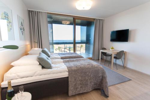 卡拉约基Santa's Resort & Spa Hotel Sani Apartments的一间卧室设有一张大床,享有海景