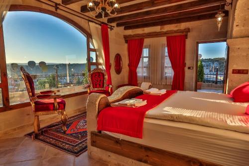 格雷梅卡帕多西亚洞穴酒店的一间卧室设有一张大床和一个大窗户