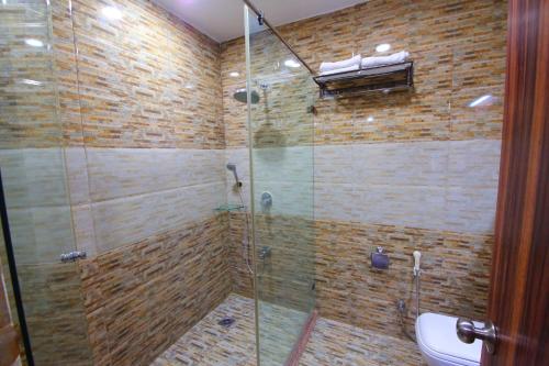 斋浦尔Lilypool - The Heritage Jalmahal的浴室设有玻璃淋浴间和卫生间
