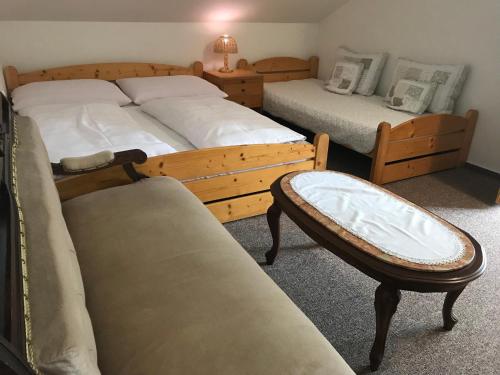 耶塞尼克Pension Iva的一间卧室配有两张床、一把椅子和一张沙发