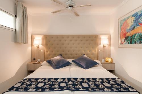 圣阿古斯丁Apartamentos Norcopia的一间卧室配有一张大床和两个蓝色枕头