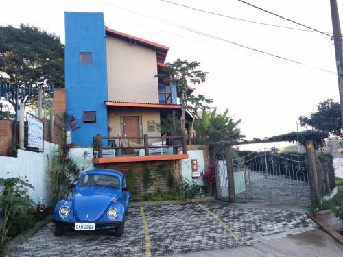 库尼亚Pousada Natureza e Arte的停在房子前面的蓝色汽车