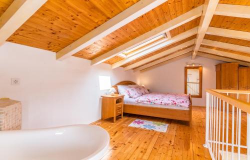 利纳迪奇Holiday Home Frankica的一间带一张床的卧室,位于带木制天花板的房间内