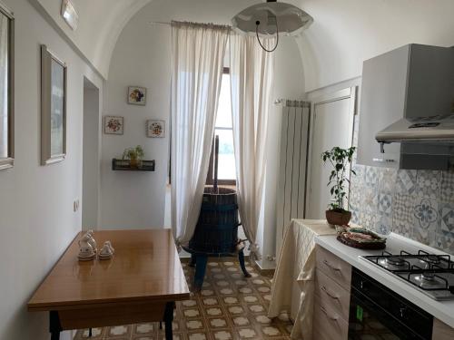 莫托拉masseria chianca " Le Gravine"的厨房配有桌子、炉灶和窗户。