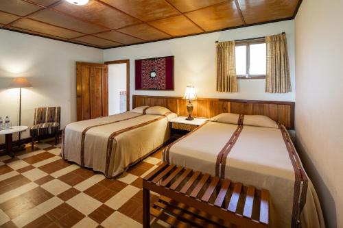 帕纳哈切尔瑞吉斯酒店Spa的酒店客房设有两张床和一张桌子。