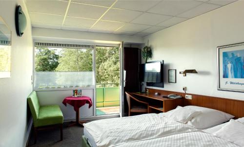霍尔茨明登斯莱穆勒酒店的一间卧室配有一张床、一张书桌和一个窗户。