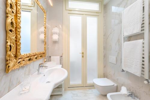 威尼斯Canal View San Marco Luxury Rooms的一间带水槽、镜子和卫生间的浴室