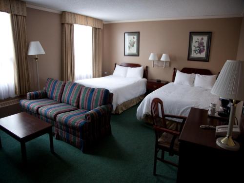 萨斯卡通森纳特酒店的酒店客房,设有两张床和一张沙发