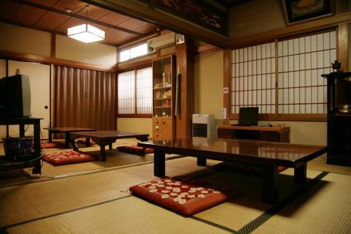 中津川市马笼茶屋的一间设有两张乒乓球桌和窗户的房间