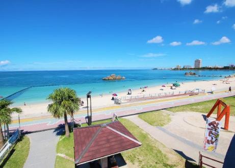 北谷町Alaha Blue Resort 6F -SEVEN Hotels and Resorts-的和水中的人一起欣赏海滩的景色