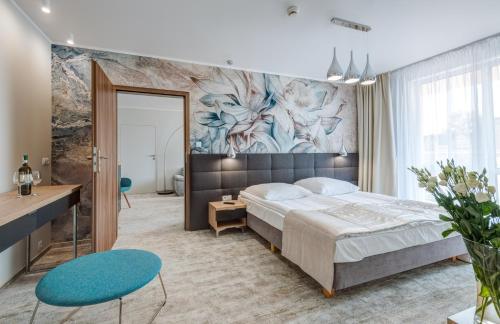 科沃布热格Hotel Zorza的卧室配有一张大床,墙上挂有绘画作品