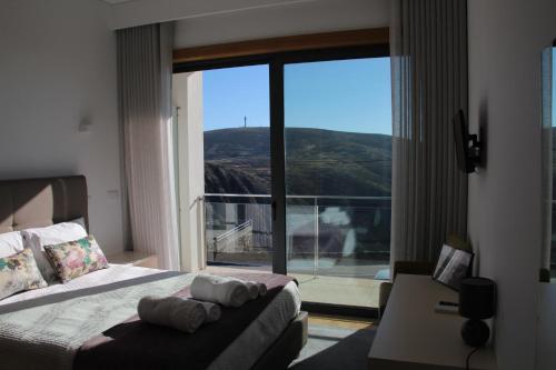 阿鲁卡Hotel Rural da Freita的一间卧室配有一张床、一张沙发和一个大窗户