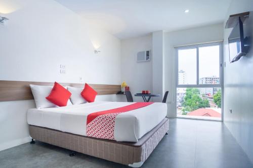 宿务18 Suites Cebu的一间卧室配有一张带红色枕头的大床